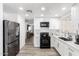 Bright kitchen with white cabinets, modern appliances, and adjacent dining area at 3009 N 81St Ln, Phoenix, AZ 85033