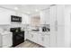 Bright kitchen featuring white cabinets, stainless steel appliances, and gray wood-look flooring at 3009 N 81St Ln, Phoenix, AZ 85033