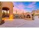 A fully equipped outdoor kitchen area with a built-in grill, fireplace, and desert landscaping at 3307 N Mountain View Rd, Apache Junction, AZ 85119