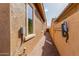 Narrow walkway between homes, featuring brick pavers and access to utilities at 3816 E Rakestraw Ln, Gilbert, AZ 85298