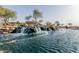 Picturesque waterfall feature with sign among lush landscaping and tranquil water, creating a serene community entrance at 3816 E Rakestraw Ln, Gilbert, AZ 85298