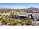 Backyard aerial view showcasing a covered patio with seating and desert landscaping and neighborhood at 3948 E Vallejo Dr, Gilbert, AZ 85298