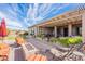 Outdoor space featuring a covered patio, fire pit, putting green and comfortable seating under a bright blue sky at 3948 E Vallejo Dr, Gilbert, AZ 85298