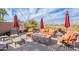 Relaxing backyard with a central fire pit, seating, and vibrant umbrellas, perfect for outdoor lounging at 3948 E Vallejo Dr, Gilbert, AZ 85298