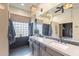 Modern bathroom with a dual sink vanity, stone floors, and unique fixtures, combining style and functionality at 3948 E Vallejo Dr, Gilbert, AZ 85298