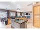 Open-concept kitchen featuring an island, granite countertops, and wood cabinets, flowing into a cozy living area at 3948 E Vallejo Dr, Gilbert, AZ 85298