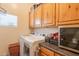 Laundry room with wooden cabinets, washer, dryer, wine fridge, and a small window at 3948 E Vallejo Dr, Gilbert, AZ 85298