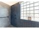 Stylish tiled shower with a pebble floor, offering a contemporary design and a glass block window at 3948 E Vallejo Dr, Gilbert, AZ 85298