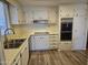 Kitchen with stainless steel sink, white cabinetry, and hardwood floors at 4065 E University Dr # 83, Mesa, AZ 85205