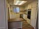 Open kitchen with white cabinets, stainless steel appliances, and hardwood floors at 4065 E University Dr # 83, Mesa, AZ 85205