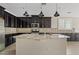 Stunning kitchen features stainless steel appliances, dark wood cabinets, granite countertops, and a large island at 4197 E Rawhide St, Gilbert, AZ 85296