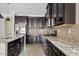 Modern kitchen with stainless steel appliances, granite countertops, and dark wood cabinetry at 4197 E Rawhide St, Gilbert, AZ 85296