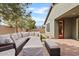 Expansive patio featuring stylish wicker furniture, a covered fire pit, and a well-manicured landscape with vibrant green grass at 4197 E Rawhide St, Gilbert, AZ 85296