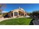 A lush backyard with a large lawn, mature trees, a patio with furniture, and a neutral-colored home at 4235 W Harrison St, Chandler, AZ 85226