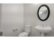 Powder room featuring a white pedestal sink, toilet and decorative oval mirror at 4235 W Harrison St, Chandler, AZ 85226