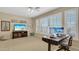 Bedroom featuring a ceiling fan, large windows, a desk, and a television over an entertainment center at 4235 W Harrison St, Chandler, AZ 85226