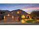 Inviting home with manicured landscaping, three-car garage, and warm exterior lighting at sunset at 4235 W Harrison St, Chandler, AZ 85226
