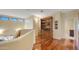 A light and bright hallway with hardwood floors and a dark wood built-in cabinet between the first and second floors at 4235 W Harrison St, Chandler, AZ 85226