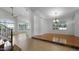 Spacious living room featuring large windows with shutters, wood floors, ceiling fan, and a stylish chandelier at 4235 W Harrison St, Chandler, AZ 85226