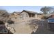 Expansive gravel backyard with desert landscaping, block wall, and defined planter beds, perfect for low-maintenance living at 43815 W Cahill Dr, Maricopa, AZ 85138