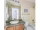Bathroom with a wooden vanity, a large sink, a decorative mirror and a bathtub with showerhead at 43815 W Cahill Dr, Maricopa, AZ 85138