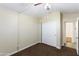 Neutral-colored bedroom with carpet flooring, ceiling fan and white closet doors at 43815 W Cahill Dr, Maricopa, AZ 85138