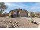 Charming home with desert landscaping, gravel, rocks, and cactus in the front yard at 43815 W Cahill Dr, Maricopa, AZ 85138