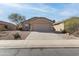 Inviting single-story home with a well-manicured desert landscape and neutral color palette at 43815 W Cahill Dr, Maricopa, AZ 85138