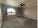 Bedroom with neutral carpeting, ceiling fan, and a window with half-round top for extra light at 4615 E Emerald Ave, Mesa, AZ 85206