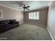 Spacious living room featuring a cozy couch, plush carpet, and a ceiling fan for added comfort at 4615 E Emerald Ave, Mesa, AZ 85206