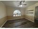 Bright and airy living room featuring new hardwood floors, ceiling fan, custom paint, updated arched window, and floating shelves at 4615 E Emerald Ave, Mesa, AZ 85206