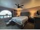 Main bedroom with a king-size bed, a large arched window, and a ceiling fan at 4615 E Emerald Ave, Mesa, AZ 85206