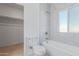 Modern bathroom with white tile surround, bathtub and new fixtures and wood-look floors at 463 W Taylor Ave, Coolidge, AZ 85128