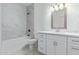 Bright bathroom featuring a tub-shower, a toilet, a sink, and white cabinets at 463 W Taylor Ave, Coolidge, AZ 85128