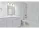 Bright bathroom featuring a tub-shower, a toilet, a sink, and white cabinets at 463 W Taylor Ave, Coolidge, AZ 85128