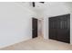 Bright bedroom featuring dark closet doors, wood-look floors, ceiling fan, and an en-suite bathroom at 463 W Taylor Ave, Coolidge, AZ 85128