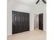 Bright bedroom featuring dark closet doors, wood-look floors, ceiling fan, and an en-suite bathroom at 463 W Taylor Ave, Coolidge, AZ 85128