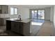 Open-concept living space with a kitchen island and sliding doors to the backyard at 5628 W Summerside Rd, Laveen, AZ 85339