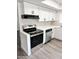 Updated kitchen with white cabinets, modern appliances, and geometric backsplash detailing at 5987 N 48Th Dr, Glendale, AZ 85301