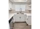 Stylish kitchen sink with stainless steel fixtures, white cabinets, and decorative tile backsplash at 5987 N 48Th Dr, Glendale, AZ 85301