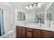 Bright bathroom featuring a dual sink vanity with wooden cabinetry and separate shower at 7038 W Beverly Rd, Laveen, AZ 85339