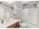 Bathroom featuring wood vanity, a shower over bath with paddle-themed decor and a rectangular mirror at 7038 W Beverly Rd, Laveen, AZ 85339