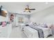 Bedroom with two beds, ceiling fan, and view of the neighborhood through the window at 7038 W Beverly Rd, Laveen, AZ 85339