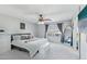 Bright bedroom features a ceiling fan, large window, and minimalist decor at 7038 W Beverly Rd, Laveen, AZ 85339