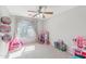 Well-lit bedroom with toys, dolls, window and ceiling fan at 7038 W Beverly Rd, Laveen, AZ 85339