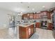 Gourmet kitchen features granite counters, dark wood cabinets, a center island and stainless steel appliances at 7038 W Beverly Rd, Laveen, AZ 85339