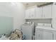 Functional laundry room with white cabinets, washer, and dryer for efficient chores at 7038 W Beverly Rd, Laveen, AZ 85339