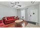 Cozy living room featuring hardwood floors, a bright window, and comfortable red sofa at 7038 W Beverly Rd, Laveen, AZ 85339
