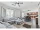 Bright open-concept living room with large sectional sofa, big windows, and an adjacent dining area at 7038 W Beverly Rd, Laveen, AZ 85339