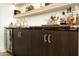 The bar area features open wood shelving with custom cabinetry and a beverage cooler at 7175 E Camelback Rd # 401, Scottsdale, AZ 85251